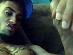 Tattooed woman masturbates suggestively in private scene.