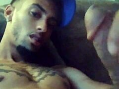 Tattooed woman masturbates suggestively in private scene.