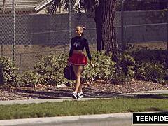 Cute cheerleader Liza Rowe shakes her pom poms energetically