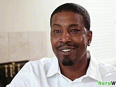 Gorgeous blonde masseuse with big boobs gives wet nuru massage naked to black client!