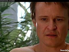 Camille Keenan teases with subtle big tits allure in Satisfaction S03E09 2010 scene.