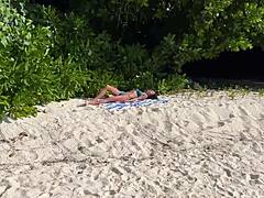 A shocked skinny babe in lingerie gets pissed on her oiled wet pussy at public beach pov
