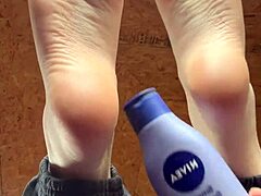 Girl smoothly applies lotion over her soft tempting feet