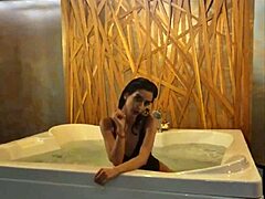 Petite brunette teases her tight ass in steamy jacuzzi